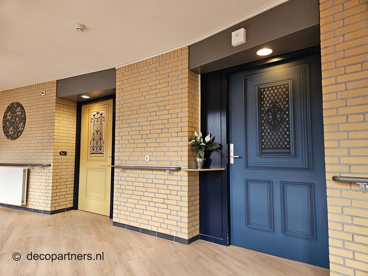 Gang in verpleeghuis met dementievriendelijke deurstickers maken de kamers herkenbaar met hun eigen voordeuren