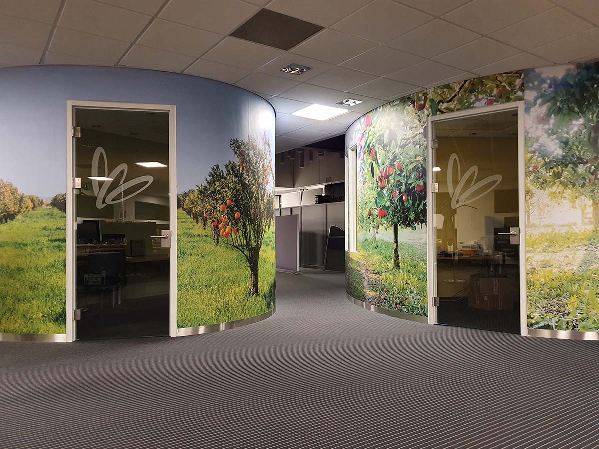Spreekkamers fruitsorteerbedrijf met wandbestickering, fotoprints fruitbomen en matte laminaatafwerking